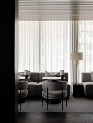 A modern living room with a sofa, two armchairs, a coffee table, and a floor lamp. - Little National Hotel Adelaide (Adelaide)