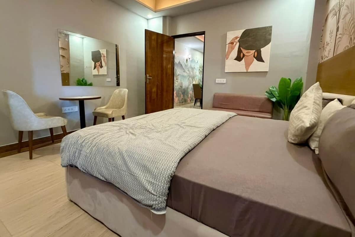 Ein modernes Schlafzimmer mit einem großen Bett, einem Schreibtisch, einem Stuhl und einem Spiegel.