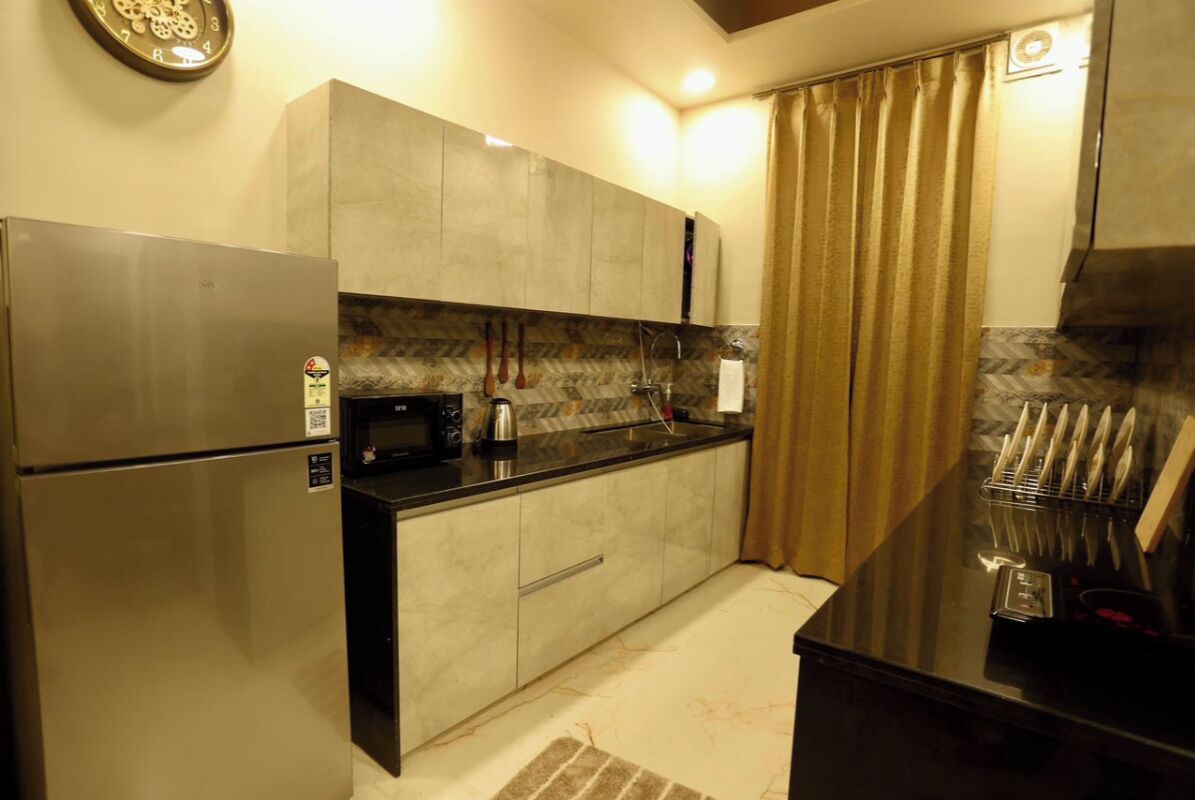 A compact kitchen with a refrigerator, microwave, and sink.