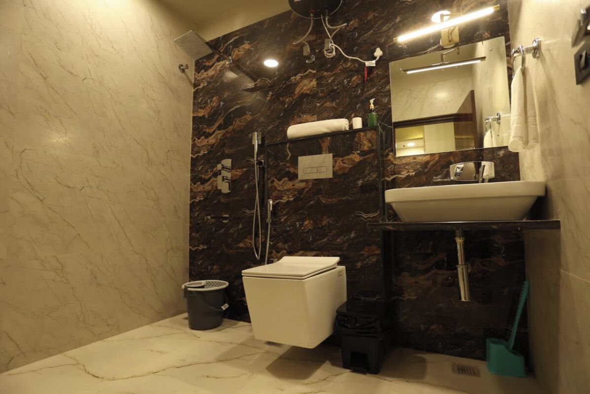 Une salle de bain comprenant des toilettes, un lavabo et un espace douche.