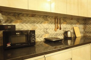 Frigorífico pequeño, microondas y utensilios de cocina