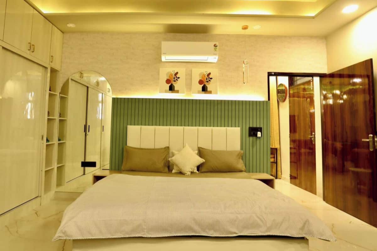 Ein Schlafzimmer mit einem großen Bett, einem Kleiderschrank, einem Schminktisch und einem Spiegel.