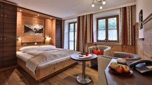 A wooden bedroom with a bed, a small table with apples, a chair, and a telephone. - Grünstein - 2-room apartment, south and east-facing balcony, 2 persons, 40 sqm, safe, kitchenette (Ramsau bei Berchtesgaden)