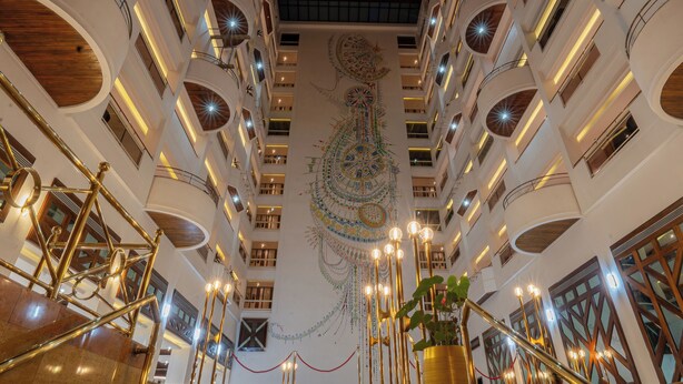 A multi-level atrium with a central spiral staircase, multiple balconies, and a decorative ceiling mural. - Iconic Plaza Hotel (Nairobi)