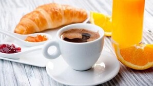 A breakfast setting with a croissant, a cup of coffee, and a glass of orange juice. - Casa d'Indie - Contemporary charm, well-being and discovery in Perpignan (Perpignan)
