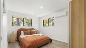 A bedroom with a bed, two bedside tables, and two windows with blinds. - New 2BR GrannyFlat,Near Movie World, Wet'Wild,Pool (Helensvale)