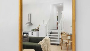 A modern living room with a sofa, a coffee table, and a dining area with chairs and a table. - New 2BR GrannyFlat,Near Movie World, Wet'Wild,Pool (Helensvale)