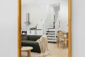 Un salon moderne comprenant un canapé, une table basse et un coin repas avec des chaises et une table.