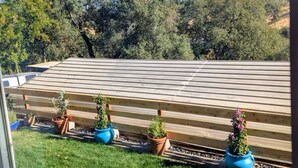 A view from a window overlooking a wooden deck with potted plants and a grassy area. - Entire home in Folsom, California (Folsom)