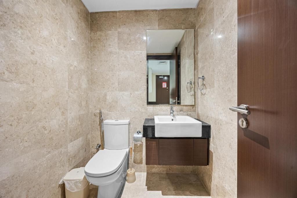 Ein Badezimmer mit Toilette, Waschbecken und Spiegel.