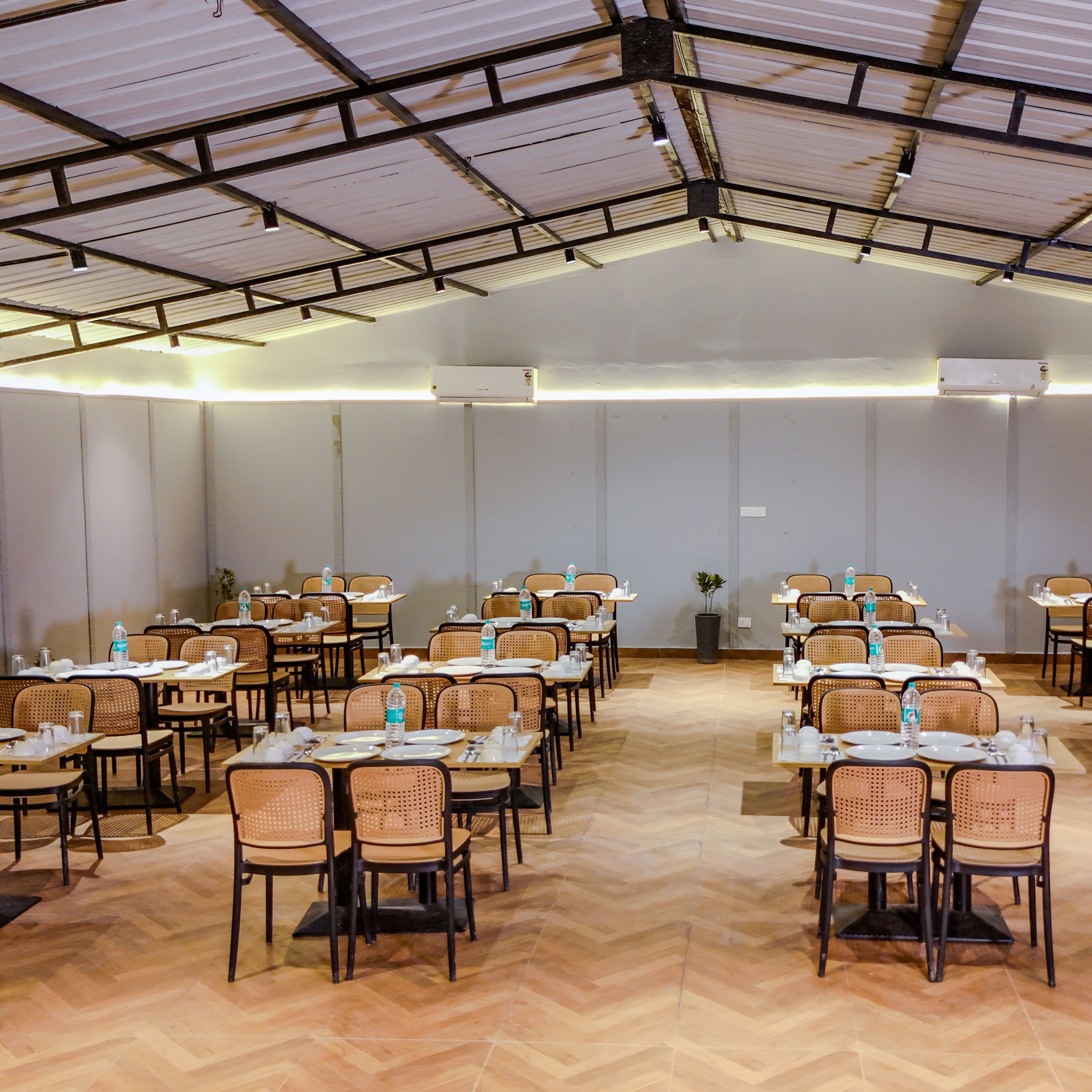 A conference room with multiple tables and chairs, arranged in rows.