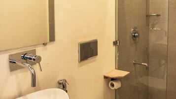 A bathroom with a white sink, toilet, and a glass-enclosed shower.
