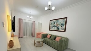 Ein modernes Wohnzimmer mit einem grünen Sofa, einem runden Couchtisch und einem Bild an der Wand.