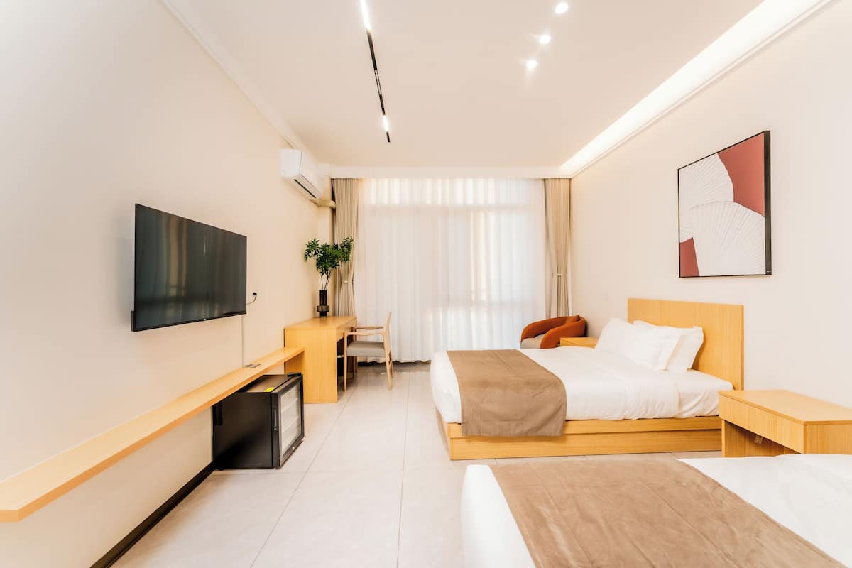 Una habitación de hotel moderna con cama, escritorio y televisor.