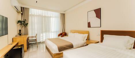 A hotel room with two beds, a desk, a chair, a TV, and a window with curtains.