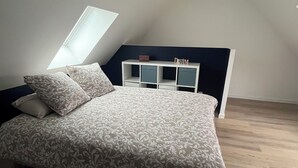 A bedroom with a bed, a white headboard, a skylight, and a hanging light fixture. - House with spa and terrace - village with amenities on foot (Acquigny)
