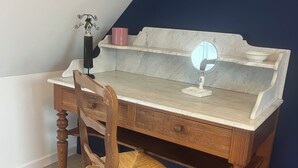 A wooden desk with a marble top, a chair with a woven seat, and a small decorative item on the desk. - House with spa and terrace - village with amenities on foot (Acquigny)
