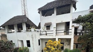 A two-story building with a pool, surrounded by greenery and a thatched-roof structure. - Jannat House Lamu (Lamu)