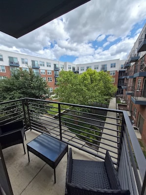 A balcony with wicker furniture, a clear view of the surrounding buildings, and a partly cloudy sky. - Luxury Frisco with 2 queen beds sleeps 4 Universal kids resort, FIFA Stay! (Frisco)