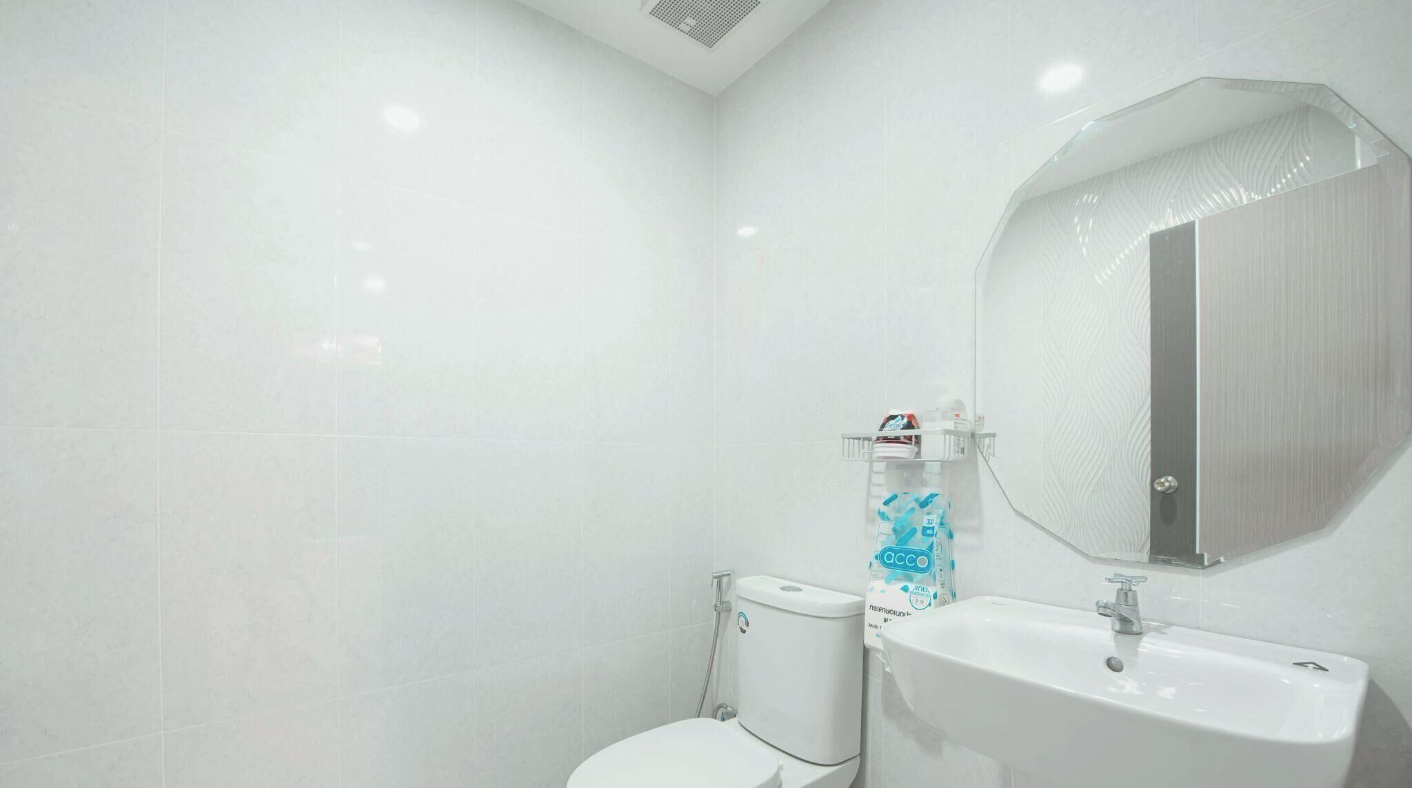 A modern bathroom with a toilet, a sink, and a mirror.