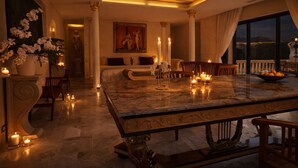 A luxurious room with a marble dining table, candles, and a large window with a view. - SECRET HOUSE- La Villa Rom'Antiqua - Ancient immersive experience (Néfiach)