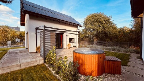 Ein modernes Haus mit Solardach, Whirlpool und überdachter Terrasse.