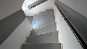 A staircase with a sloped ceiling and a red handrail. - Quiet village house in Alénya - 5km from the beaches (Alénya)