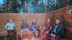 Four people seated on wooden benches around a campfire. - Family-Friendly Apartment Retreat in Dalarna Sweden (Orsa)