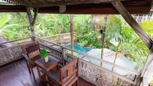 A wooden deck with a pool, surrounded by lush tropical vegetation. - Charming Deluxe room Upper floor at Ubud (Ubud)