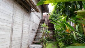 Una escalera de madera que lleva a una casa con un porche de tejas.