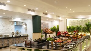A buffet area with a variety of food options, a kitchen in the background, and a decorative wall with plants. - Spacious Resort Beach Villa with Private Pool Nabq (South Sinai Governorate)