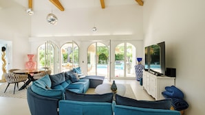 Een moderne woonkamer met een modulaire bank, een televisie en uitzicht op de omgeving.