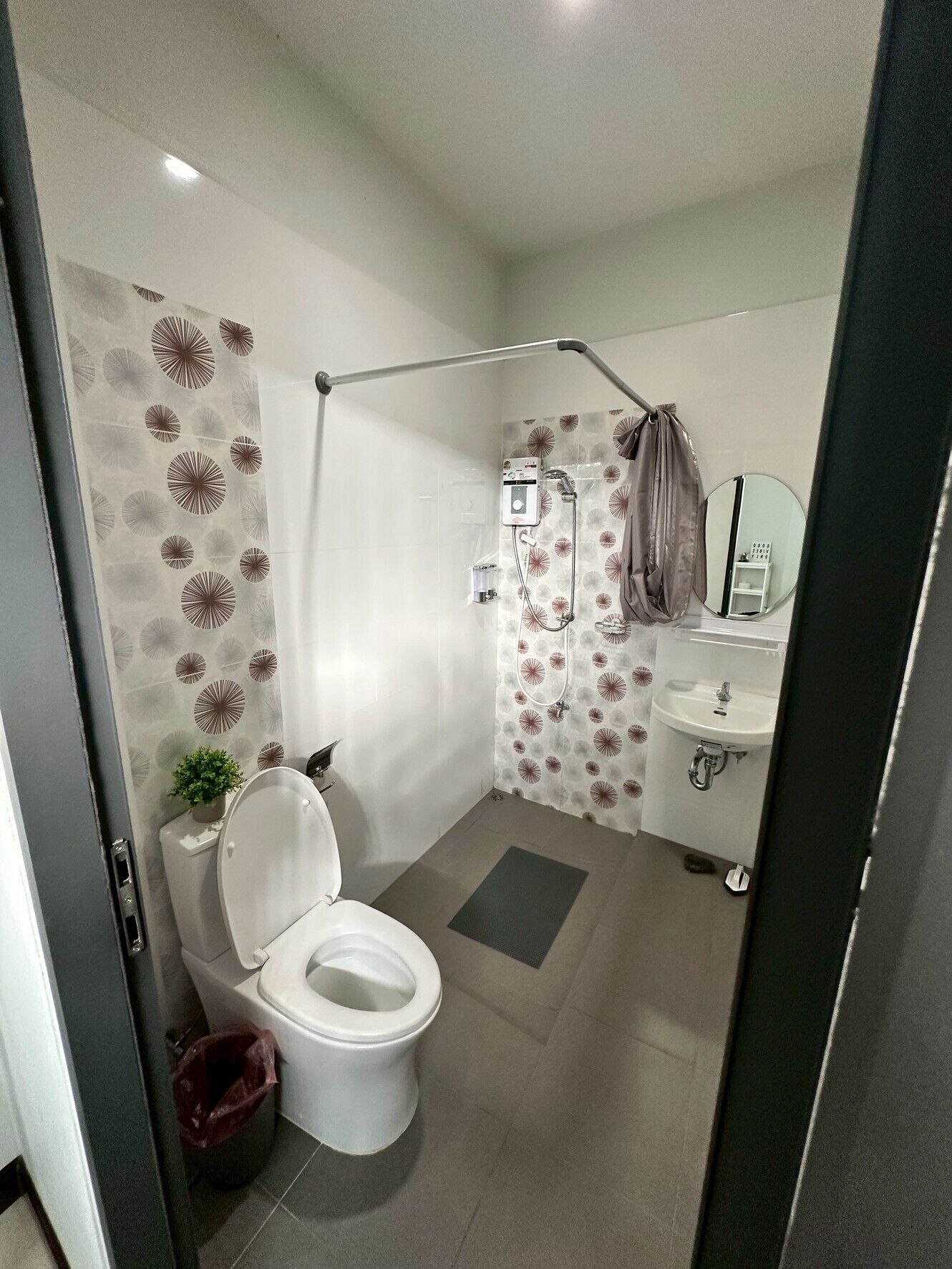 Een moderne badkamer met toilet, douche en wastafel.