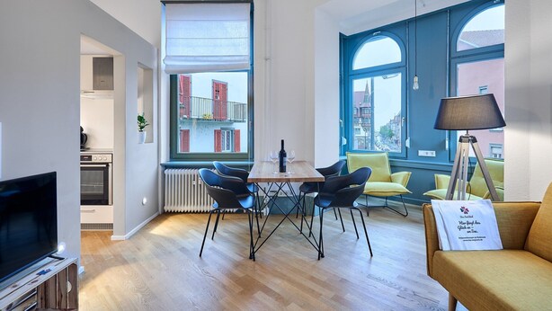 A modern living room with a dining table, chairs, a TV, and a sofa. - Studio | Old Town | seeglueck (Konstanz)
