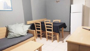 Ein kleiner, gemütlicher Raum mit einer Couch, einem Tisch und Stühlen.