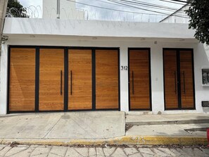A building with four large wooden doors, each with a black handle. The number 312 is visible on the wall to the right of the doors. - Charming 2BR Apt in Oaxaca (Oaxaca de JuÃ¡rez)