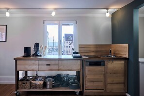 Eine moderne Küche mit Blick auf Gebäude, einer Holzausziehtafel und einem Geschirrspüler.