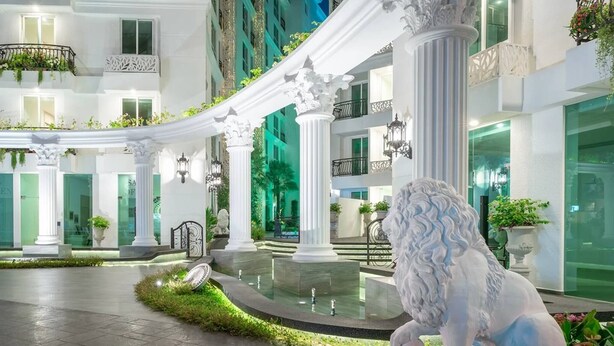 A grand hotel atrium with white columns, a lion statue, and a fountain. - Resort Style Living - Great Location At Pattaya (Pattaya)