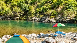 A campsite with tents and a table with chairs by a clear river. - Wild Vista Marchula Riverside Resort Jim Corbett (Marchula)