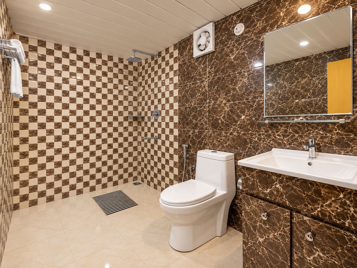 Een badkamer met een betegelde muur in ruitpatroon, een wit toilet, een wastafel en een spiegel.