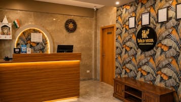 A reception area with a wooden reception desk, a clock, and a wall with framed certificates.