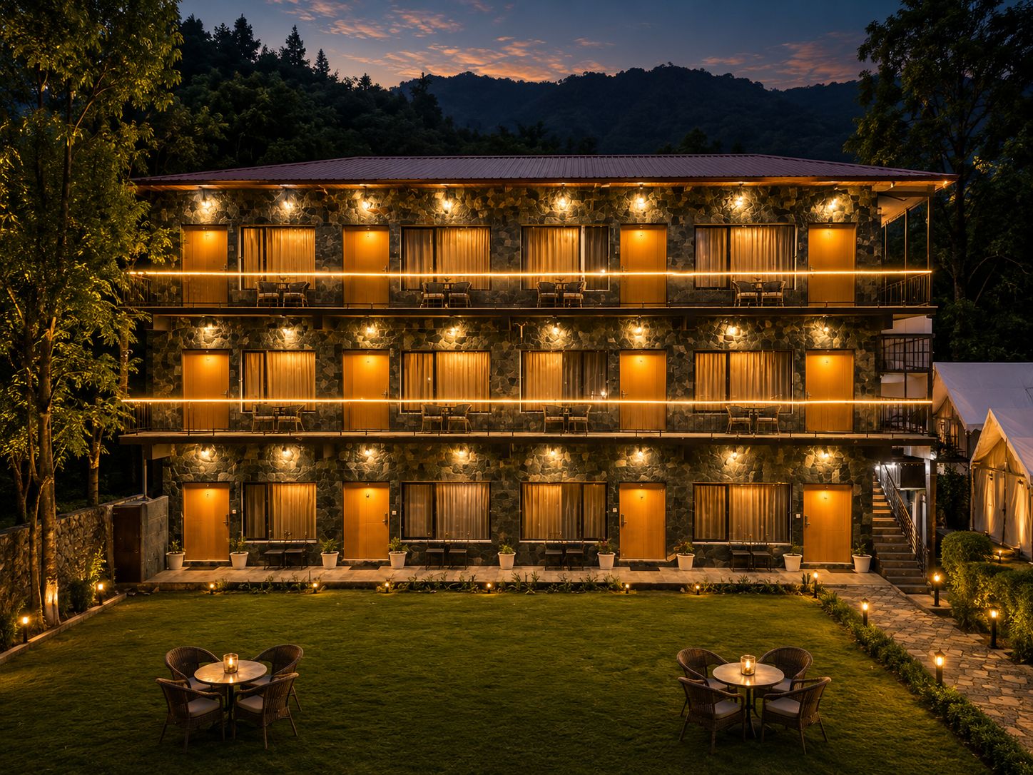 Um hotel de vários andares com fachada de pedra, várias varandas e áreas de estar ao ar livre.