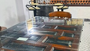 A conference table with a glass top and wooden frame, chairs with cushioned seats, and a tiled floor. - Casa cubo (Alhama de Granada)