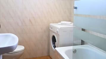 Tweepersoonskamer | Badkamer | Een douche, een haardroger, handdoeken, zeep
