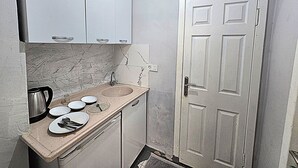 Une petite salle de bain avec un lavabo, un miroir et une porte.