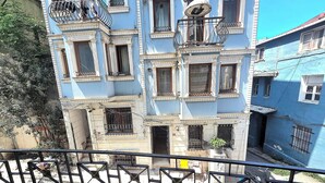 Un immeuble à plusieurs étages doté de balcons, avec une entrée au rez-de-chaussée bien visible et un ciel dégagé.