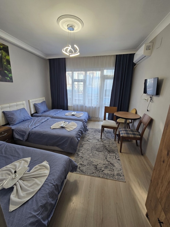 Habitación triple Deluxe, balcón | Tabla de planchar con plancha y wifi gratis