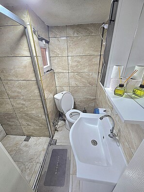 Habitació quàdruple Deluxe | Bany | Dutxa, assecador de cabells, sabatilles i tovalloles 