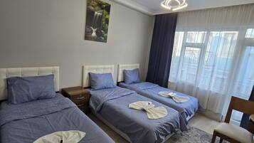 Habitación triple Deluxe, balcón | Tabla de planchar con plancha y wifi gratis