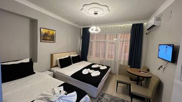 Une chambre d’hôtel avec deux lits, une télévision, un bureau et une chaise.